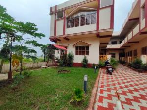 a house with a lawn in front of it at Tanubithi Resort in Bolpur