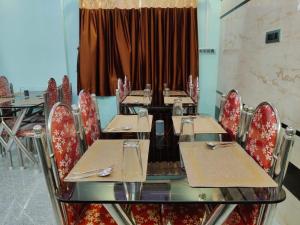 a dining room with tables and chairs and a curtain at Tanubithi Resort in Bolpur