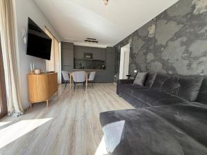 a living room with a couch and a table at Mountain Place to Remember - River & Barbecue in Buşteni