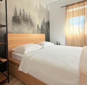 een slaapkamer met een groot wit bed en een raam bij Mountain Place to Remember - River & Barbecue in Buşteni