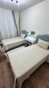 2 camas en una habitación con un ordenador portátil en un escritorio en Dimer country 27, en Beylikduzu