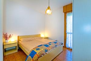 um quarto com uma cama e duas mesas e uma janela em Residence Sabrina em Bibione