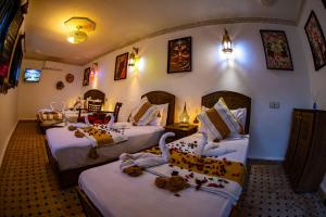 a hotel room with two beds with swans on them at Riad Hikaya - Fes Story in Fès