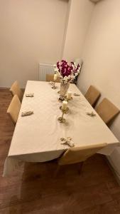 Una mesa blanca con un jarrón de flores. en Dimer country 27, en Beylikduzu