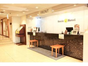 a smile hotel counter in a mall with two stools at Smile Hotel Wakayama - Vacation STAY 69556v in Wakayama