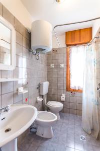 uma casa de banho com um WC branco e um lavatório. em Residence Sabrina em Bibione