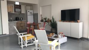 ein Wohnzimmer mit Fernseher und Tisch und Stühlen in der Unterkunft Matony in La Playa Bejarano