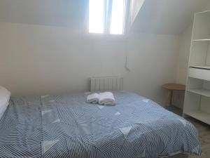 a bedroom with a bed with two towels on it at Tiny duplex in Caen +8 photos