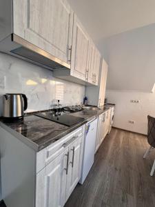 a kitchen with white cabinets and a counter top at Small House ApartHotel in Chişinău