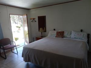 Un dormitorio con una gran cama blanca y una silla. en Country Inn LLC, en Townsend