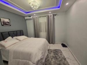 a bedroom with a large bed with a blue lighting at Siewoue BTP sarl in Mfou