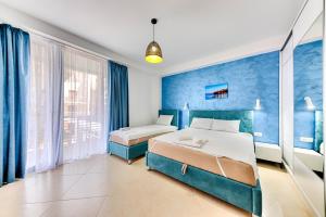 1 Schlafzimmer mit 2 Betten und blauen Wänden in der Unterkunft Lotos -apart 209 L1 in Dobra Voda