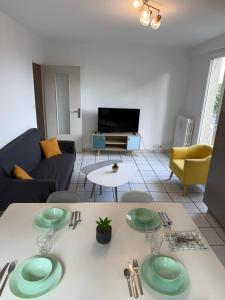 a living room with a table with green plates on it at Spacious, bright 4 bedroom, 80 m2 in Hérouville-Saint-Clair