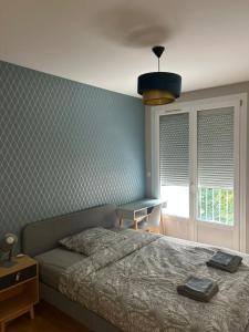 a bedroom with a bed and a table and a window at Spacious, bright 4 bedroom, 80 m2 in Hérouville-Saint-Clair