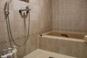 une salle de bain avec douche, baignoire et toilettes dans l'établissement Sun Sea Cottage - Vacation STAY 75453v, à Tagawa
