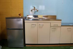 une cuisine avec un évier et un réfrigérateur dans l'établissement Sun Sea Cottage - Vacation STAY 75460v, à Tagawa