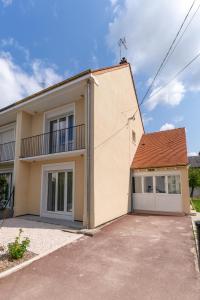 a house with a balcony and a garage at Les Sorbiers & spa in Saint-Avertin
