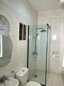 a bathroom with a shower and a toilet and a sink at Woodhaven apartment in Kubwa
