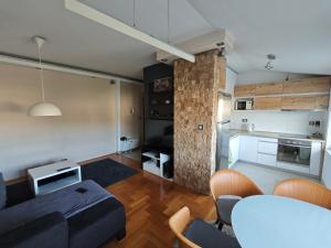 a living room with a blue couch and a kitchen at Sunny River BL in Banja Luka