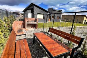 eine Holzbank vor einem Haus in der Unterkunft LUXURY Casa cerca al centro en El Calafate Glacial, Argentina in El Calafate