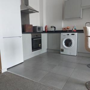a kitchen with a washing machine and a washer at Ensuite Double Bedroom, Live in landlord in Warrington