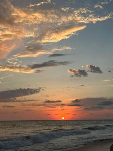 a sunset on the beach with the sun setting at Ocean Front- Marina View- Tiara Sands Resort, Sleeps 4 in Mazatlán