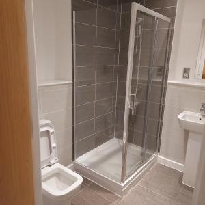 a bathroom with a shower and a toilet and a sink at Ensuite Double Bedroom, Live in landlord in Warrington