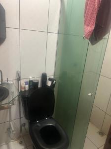 a bathroom with a black toilet and a glass shower at Casa Maria in Belém