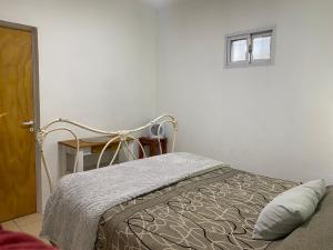 a bedroom with a bed and a window on the wall at La quinta in Piquete