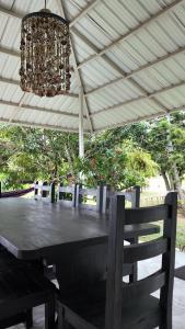 a wooden table with chairs under a roof at Finca en Chinauta, piscina, jacuzzi, BBQ in Boquerón