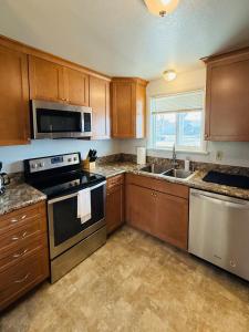 a kitchen with wooden cabinets and a stove and a sink at Siesta Sunset in Boise