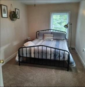 a bedroom with a bed in a room with a window at Stylish And Convenient With Wifi & Fenced Yard in Charlottesville
