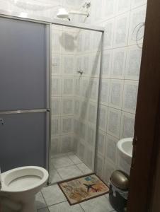 een badkamer met een douche, toilet en wastafel bij Hostel São Francisco 1 in Votorantim