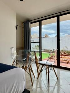 1 Schlafzimmer mit einem Glastisch und 2 Stühlen in der Unterkunft Hermoso y brillante alojamiento con piscina in Mérida
