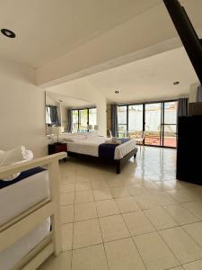 ein großes Schlafzimmer mit 2 Betten und einem Balkon in der Unterkunft Hermoso y brillante alojamiento con piscina in Mérida