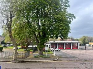 a tree in a parking lot in front of a building at Budget Stay In Luton 01 R in Luton