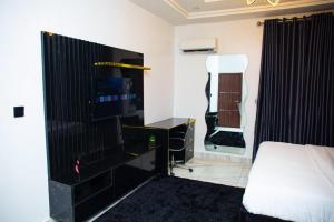 Un dormitorio con una cama y un televisor en una habitación. en 1 Bedroom Apartment in lifecamp, en Gwarinpa 2 fotos más