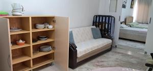a room with a chair and a shelf with dishes at Günışığı Pansiyon & Apart in Koycegiz