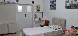 a bedroom with a bed and a mirror and a chair at Günışığı Pansiyon & Apart in Koycegiz +11 photos