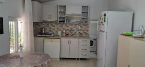 a kitchen with white appliances and a white refrigerator at Günışığı Pansiyon & Apart in Koycegiz