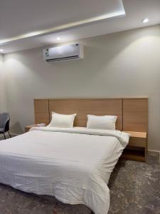 a bedroom with a large bed with white sheets at Studio with a calm and comfortable designse in Al ‘Awālī