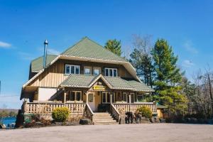 a large house with people standing in front of it at CHALET AT THE BEACH in Otter Lake