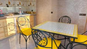 a kitchen with a table and chairs and a counter at Dar Salam Asfi - Maison d'hôtes, terrasse vue Medina et océan in Safi +61 photos