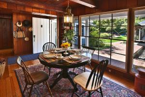 a dining room with a table and chairs and a large window at Rincon Retreat by Paradise Retreats in Carpinteria