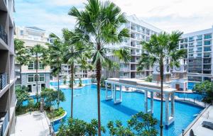 una vista aérea de una piscina con palmeras y edificios en Arcadia Beach 芭提雅市中心公寓, en Pattaya South