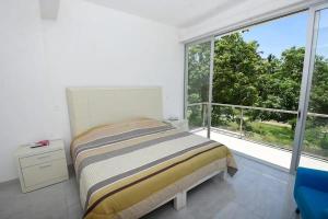 ein Schlafzimmer mit einem Bett und einem großen Fenster in der Unterkunft NEW Bamboo Pacifica in Acapulco + 61 Fotos
