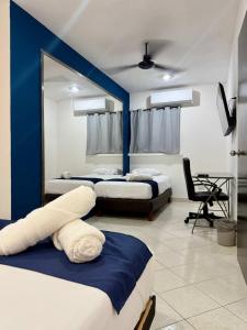 ein Schlafzimmer mit zwei Betten und einer blauen Wand in der Unterkunft Sunlit Hideaway plus shared Pool for 6 in Mérida