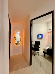 Zimmer mit einem Spiegel, einem Stuhl und einem Bett in der Unterkunft Sunlit Hideaway plus shared Pool for 6 in Mérida