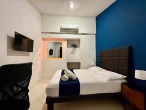 ein Schlafzimmer mit einem Bett mit einer blauen Wand in der Unterkunft Sunlit Hideaway plus shared Pool for 6 in Mérida + 19 Fotos