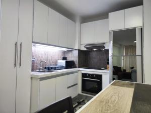 a kitchen with white cabinets and a wooden counter top at Tus vacaciones Ideales en Costa Azul Isla de Margarita in Porlamar